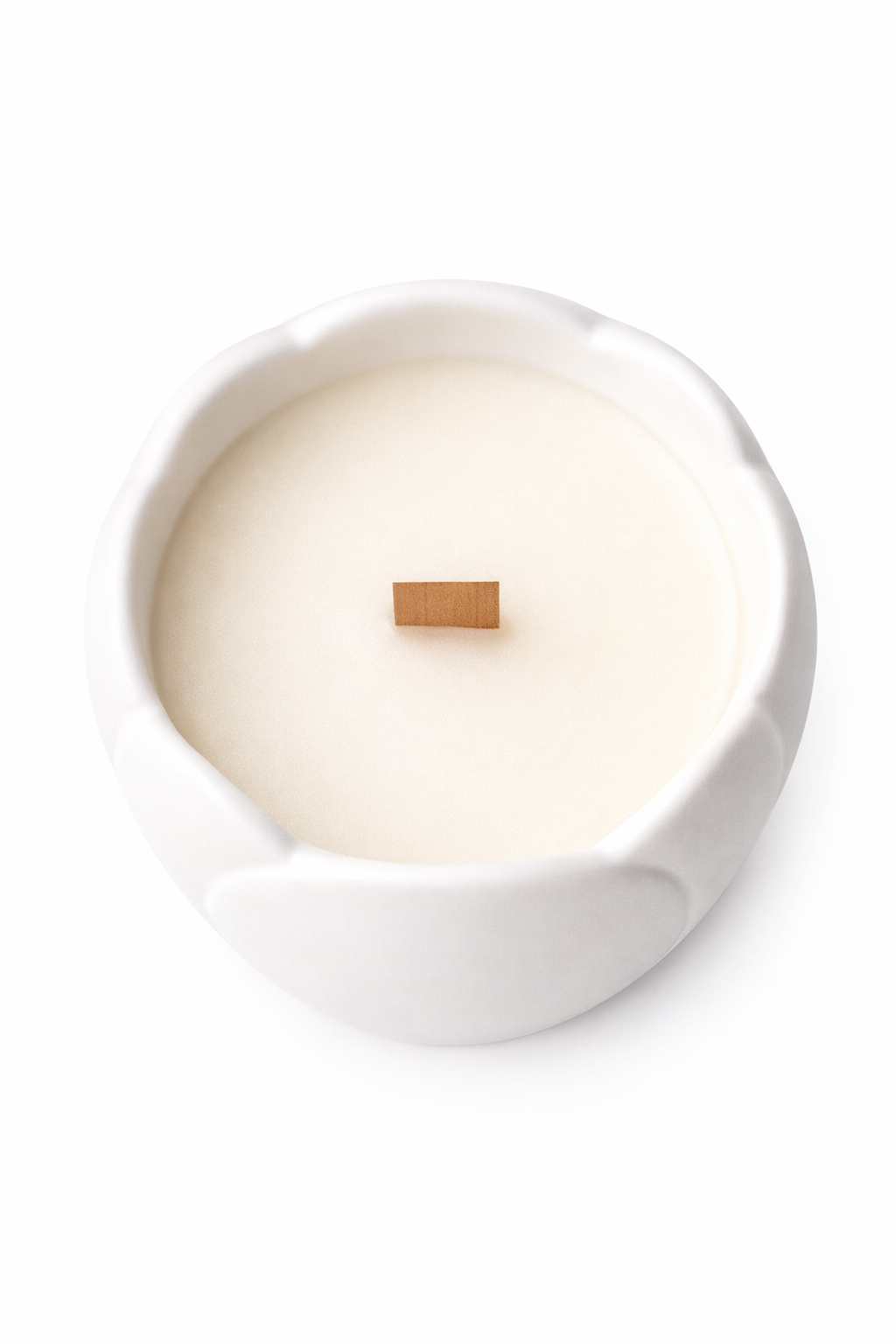 Top-down view of Lumine Rose & Sandalwood soy wax candle in a magnolia-shaped porcelain vessel showing the wax surface and wooden wick.
